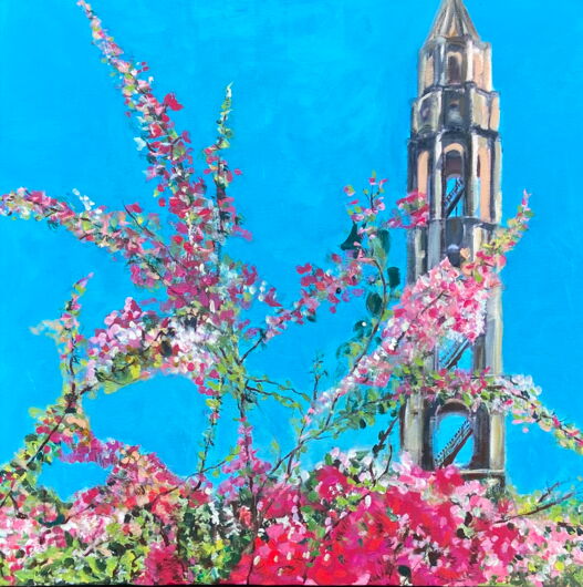 Das Bild zeigt den Sklaventurm im Tal der Zuckermühlen auf Kuba vor blauem Himmel mit leuchtenden Blüten.